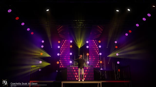 Moving lights washing a stage in colour